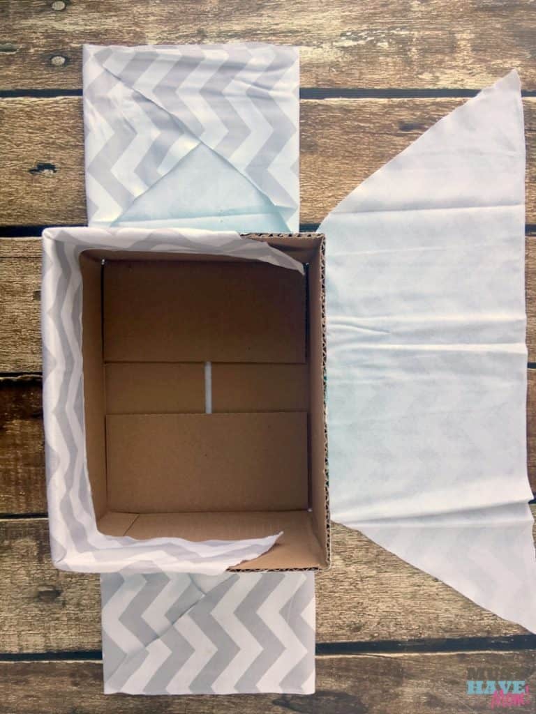 How to turn a cardboard box (like a diaper box) into a fabric covered basket! No sew method of making a fabric lined basket to compliment nursery decor! Make it for free with upcycled supplies!