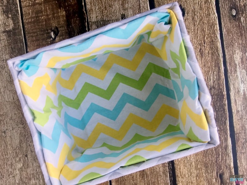 How to turn a cardboard box (like a diaper box) into a fabric covered basket! No sew method of making a fabric lined basket to compliment nursery decor! Make it for free with upcycled supplies!
