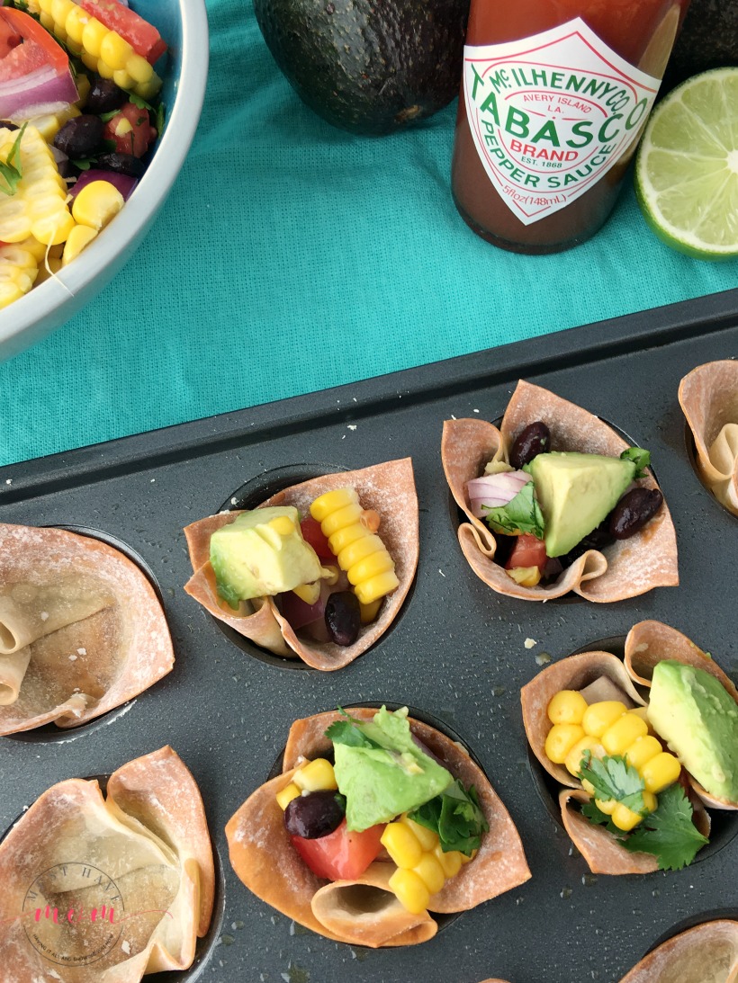 Spicy shrimp wonton cups with black bean corn avocado guacamole. Great party appetizer for the big game!