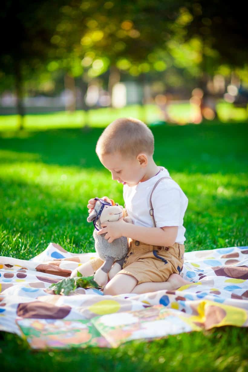 Boy playing outside on a blanket