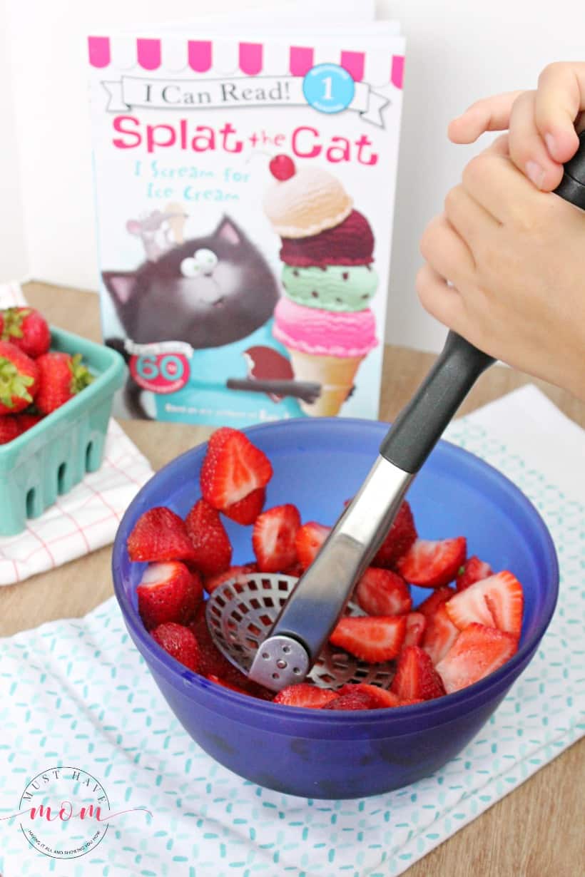 crushing strawberries in a bowl