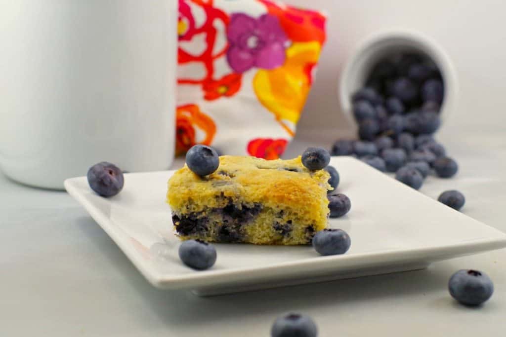 A piece of blueberry cornbread on a white plate 